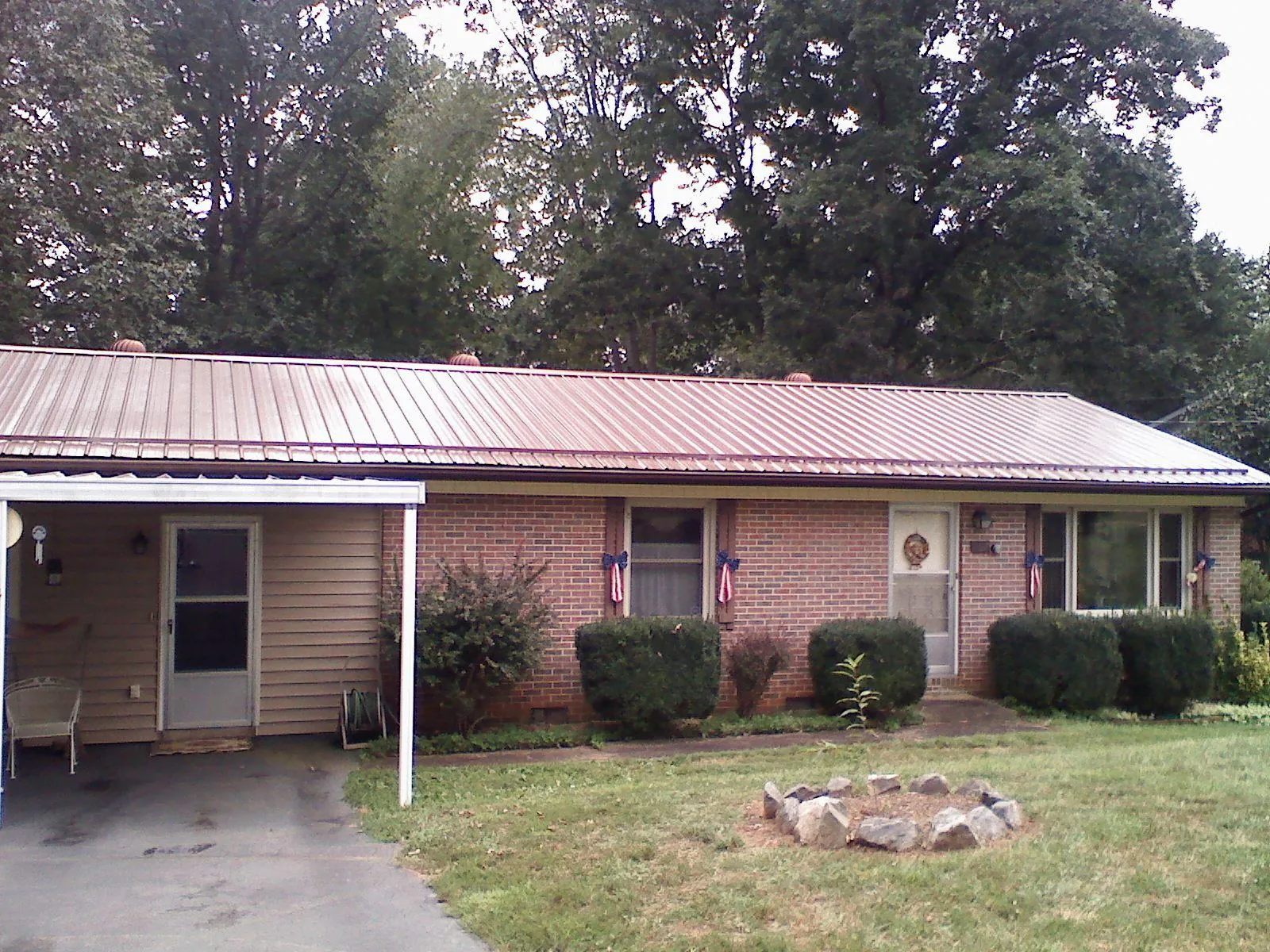 Bronze metal roof and carport on a brick ranch home — Roof Repair work by our crew in Berea